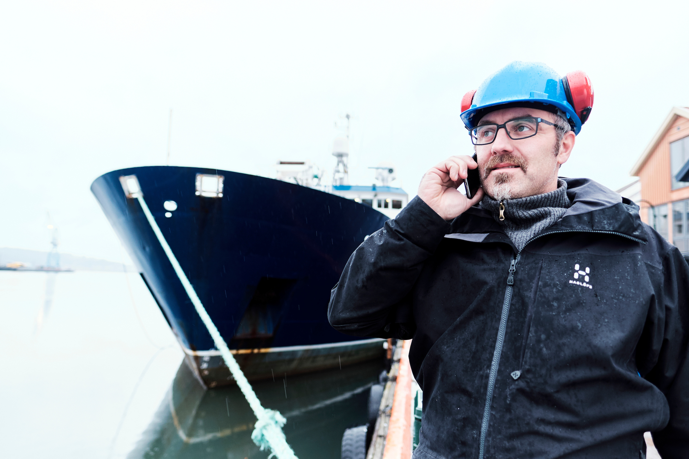 Man talking on the phone next to a ship