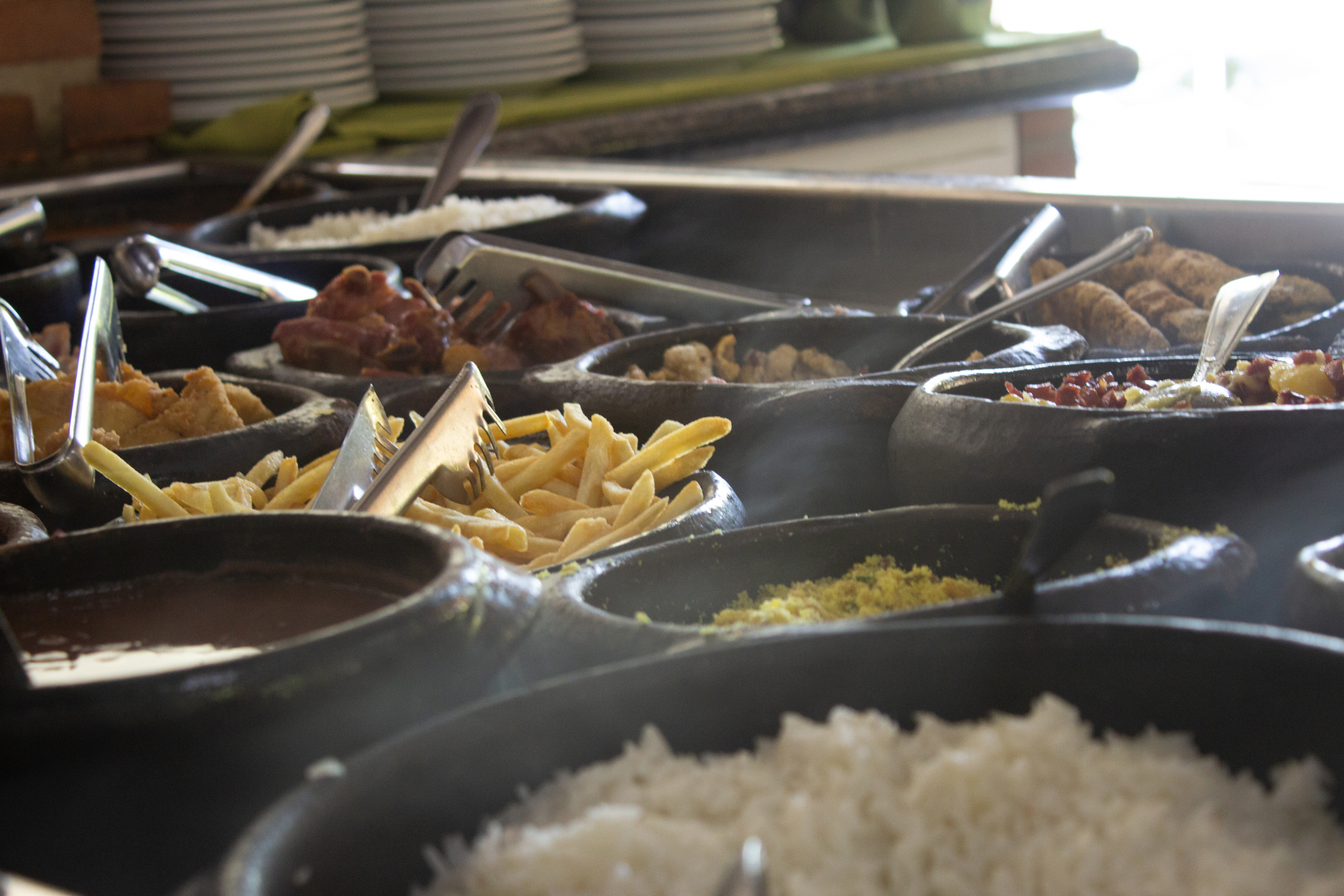 Matbufeet med blant annet ris, pommes frites, kjøtt, i forskjellige beholdere i et varmeskap
