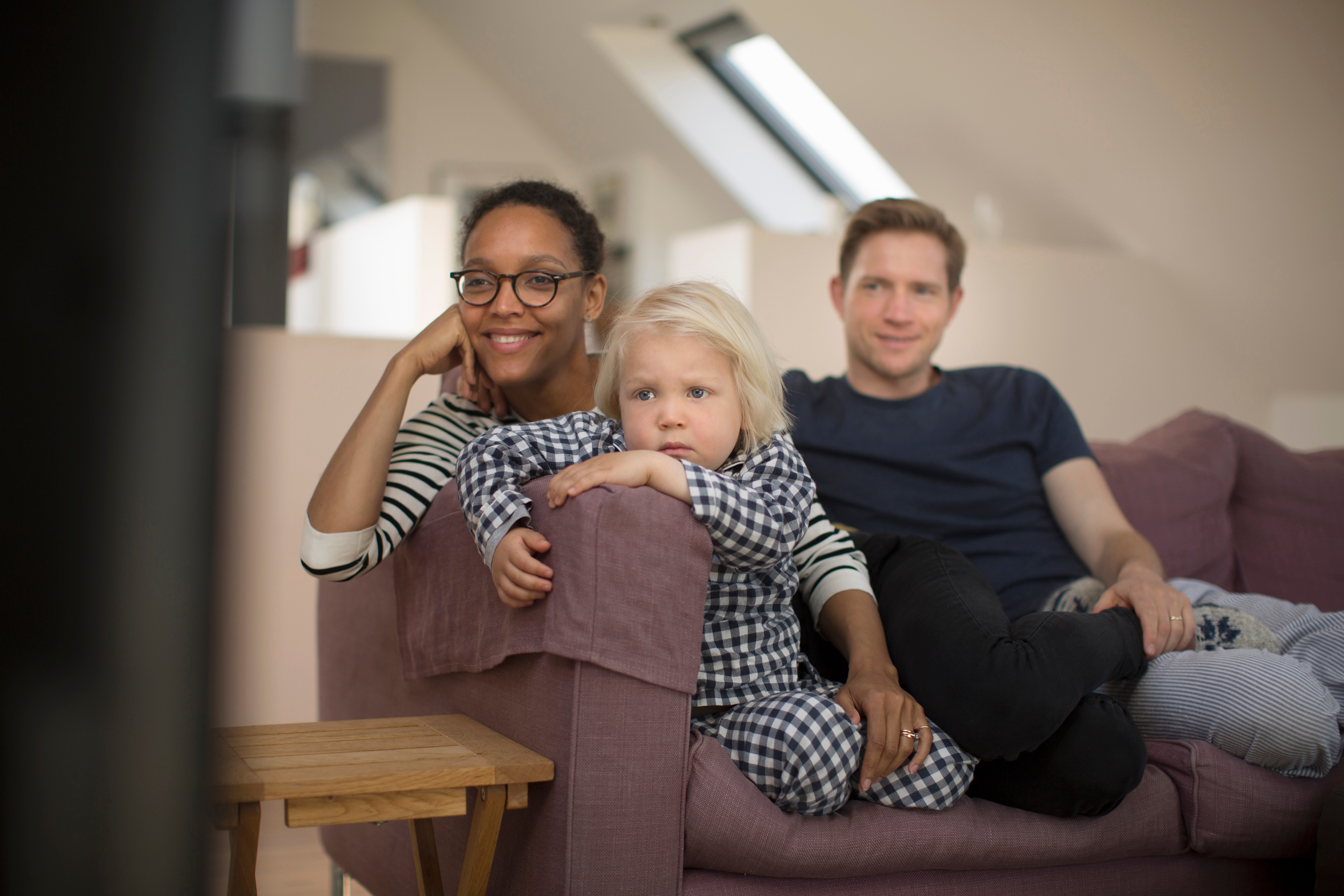 Familie slapper av i sofa