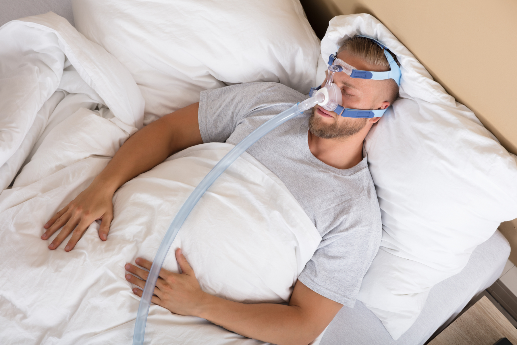 Bilde av mann som sover med en CPAP-maskin