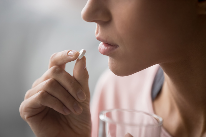 A woman taking a pill