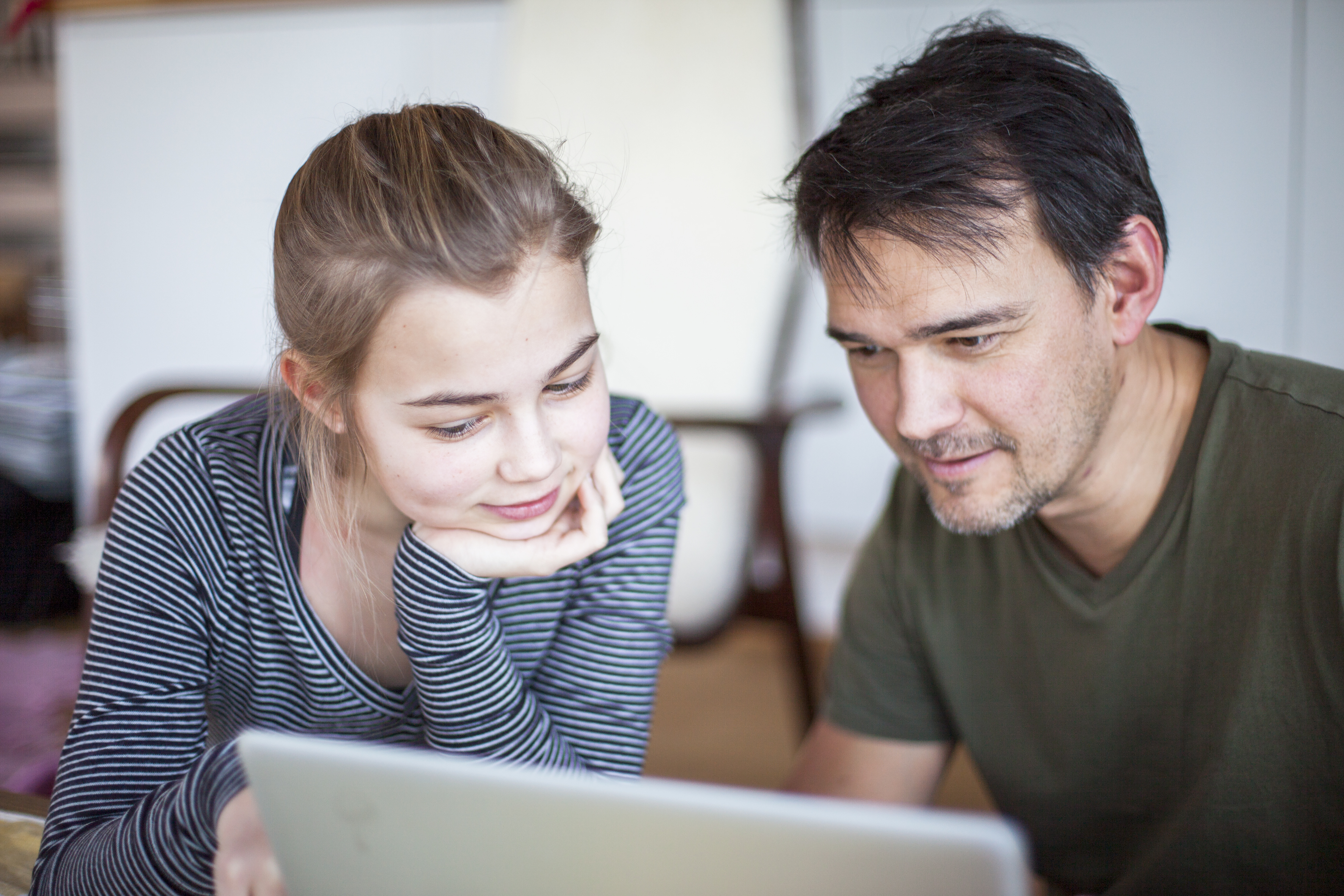 Far og datter ser på laptopen