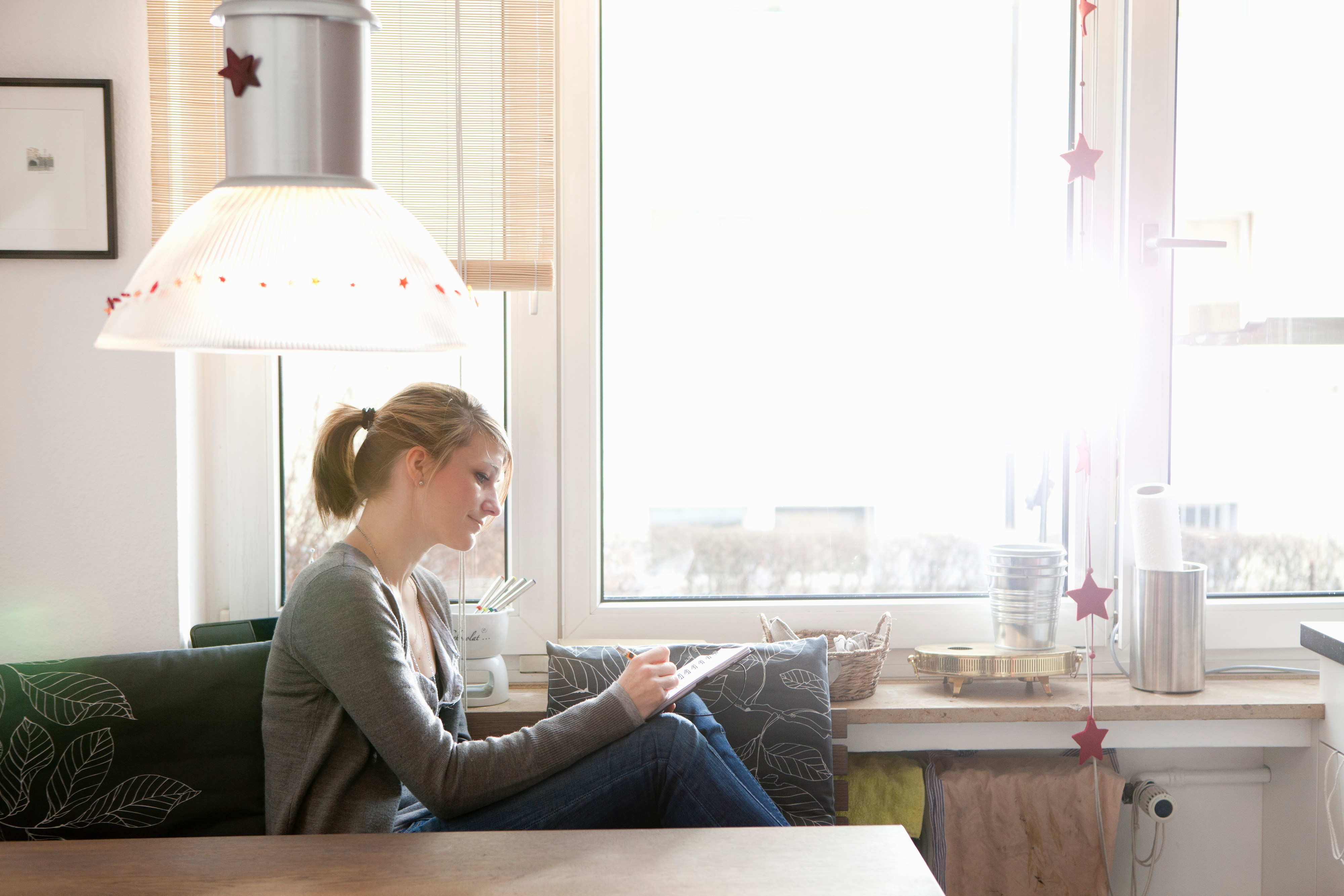 Kvinne skriver i sofaen