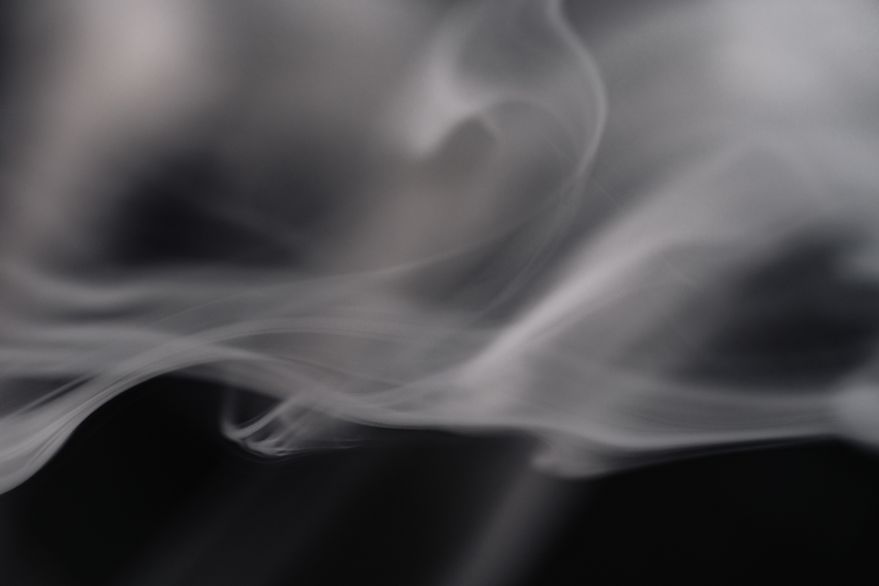 Illustrasjon av grå røyk mot svart bakgrunn