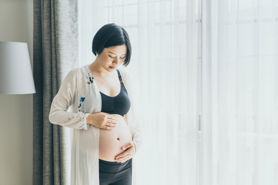 Pregnant woman looking at her belly