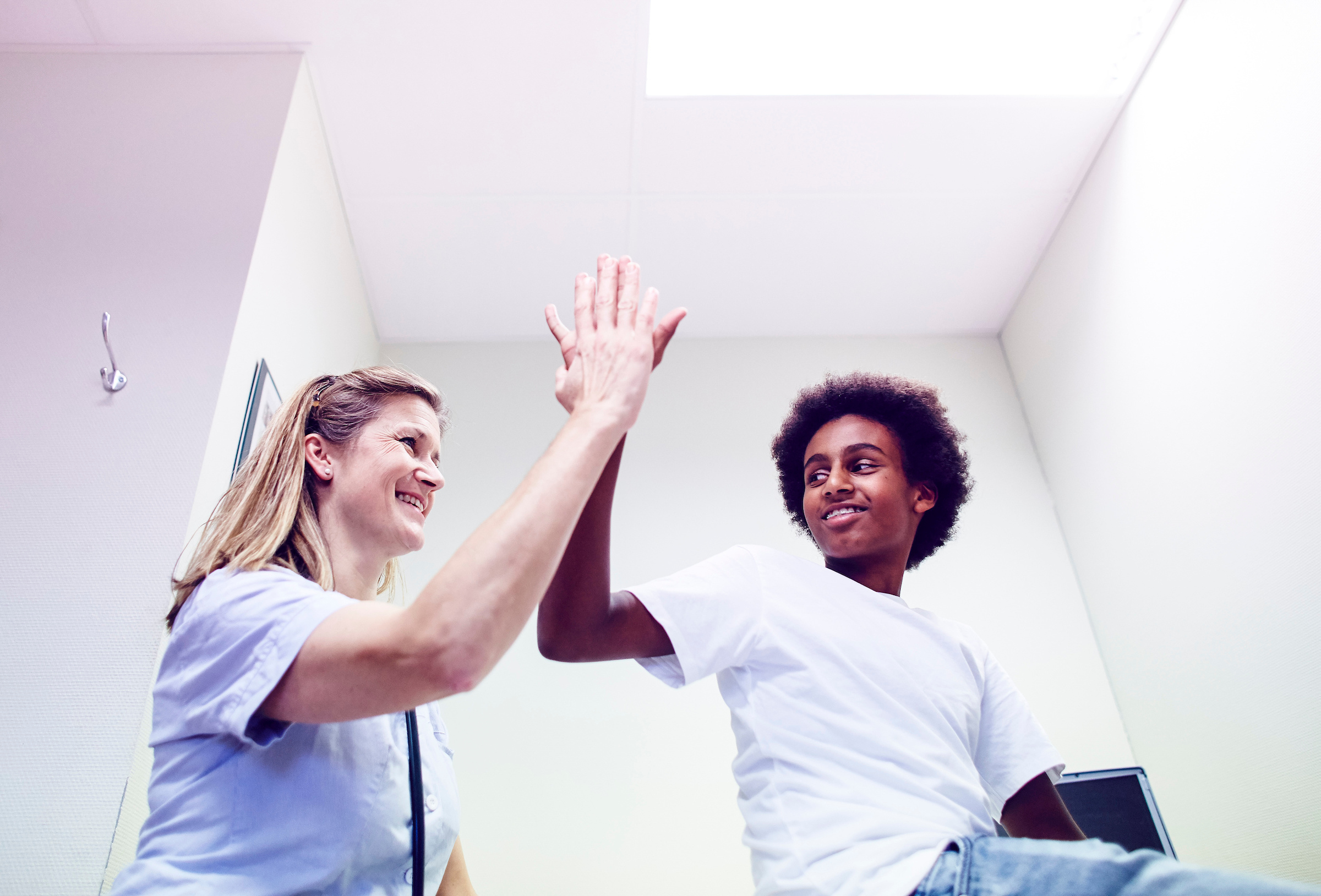 Sykepleier og pasient gir hverandre en high five