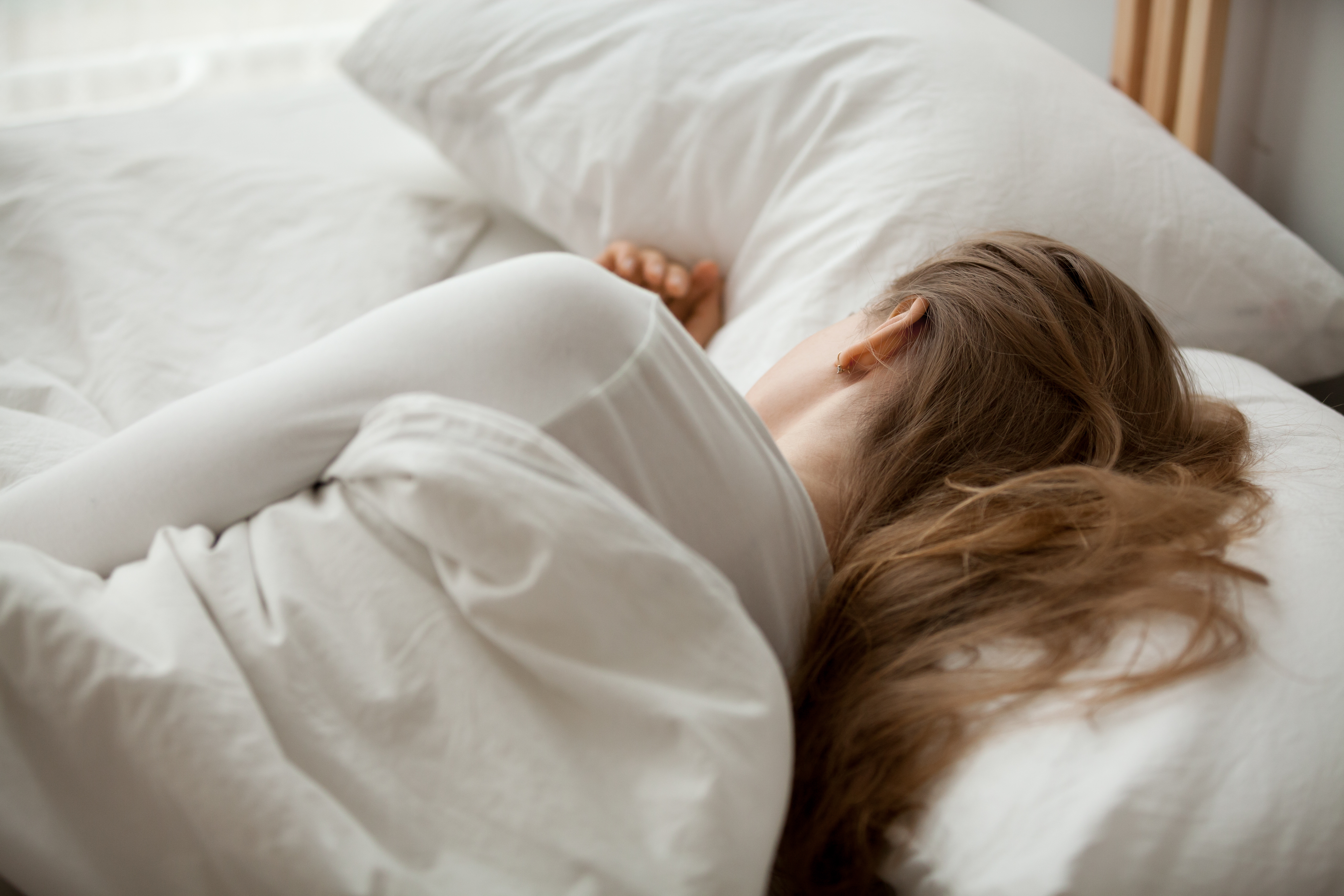Kvinne sover i en seng
