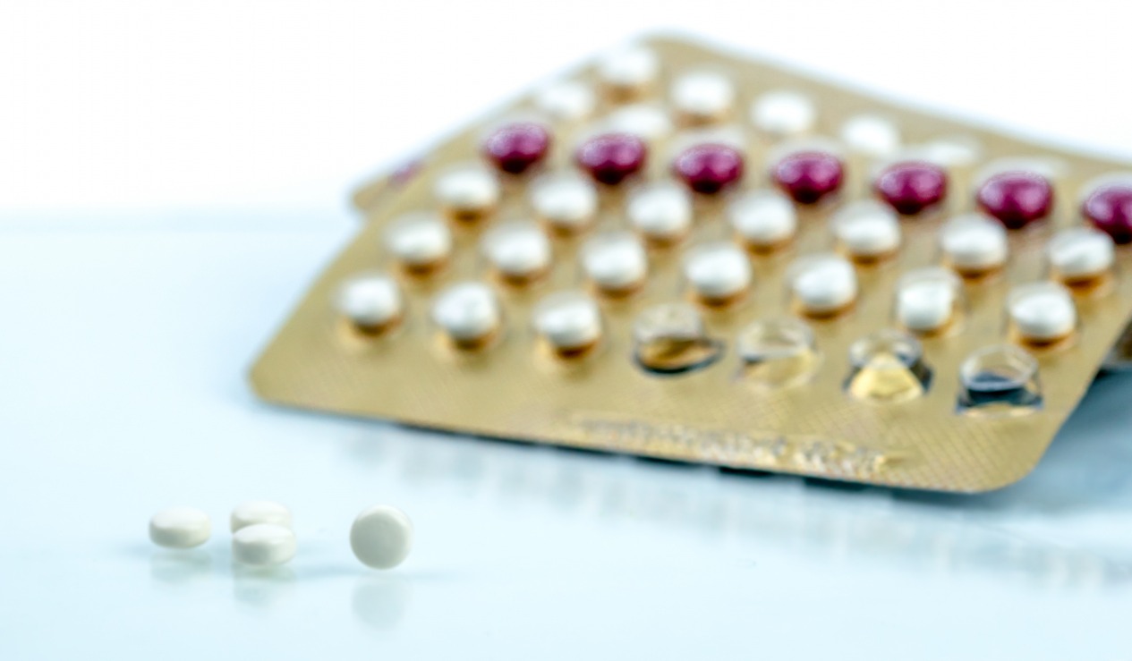 To brett med p-piller liggende på et lyseblått underlag