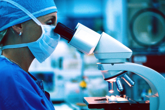 Woman looking into microscope