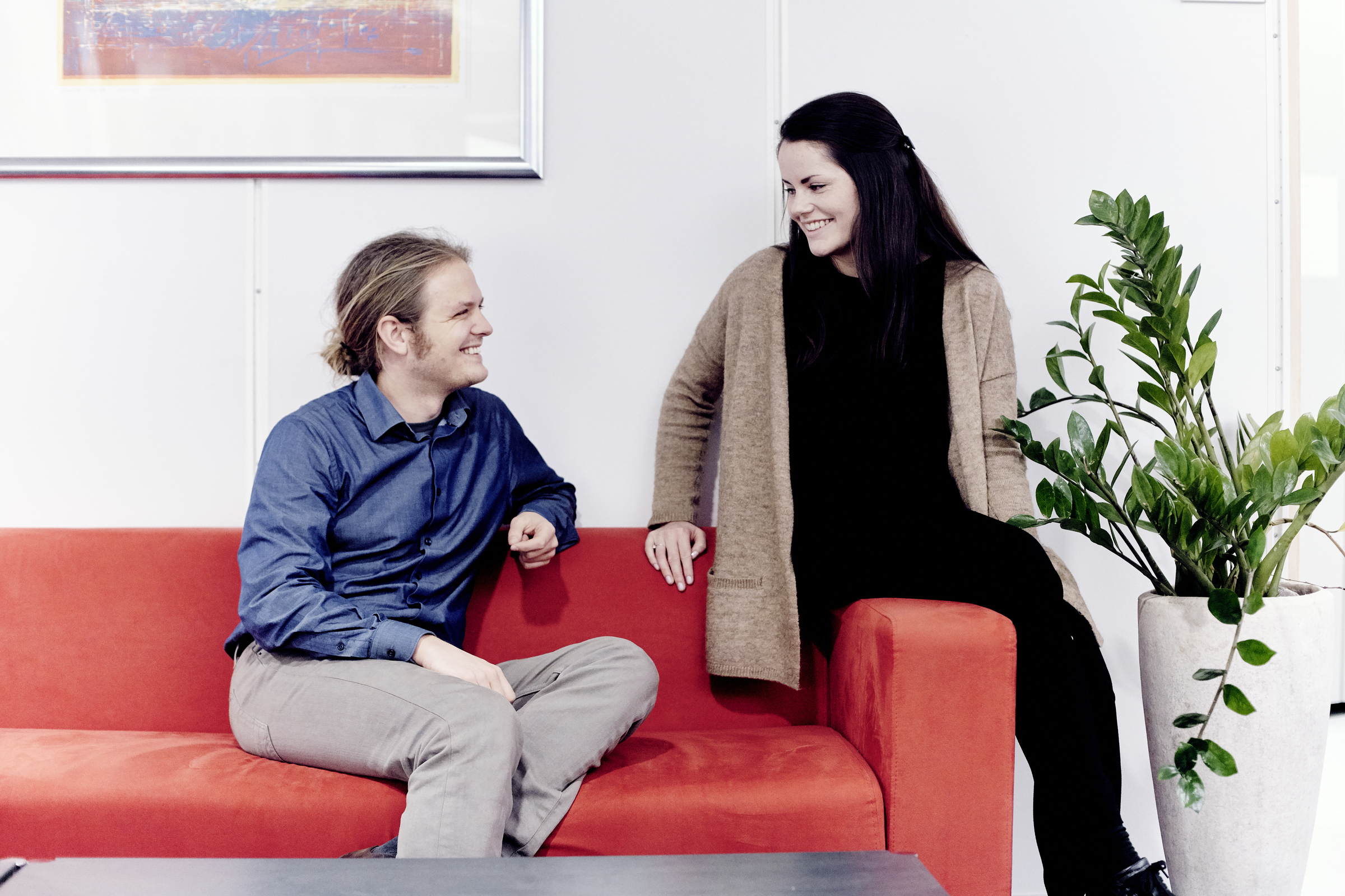 Ungt par i rød sofa