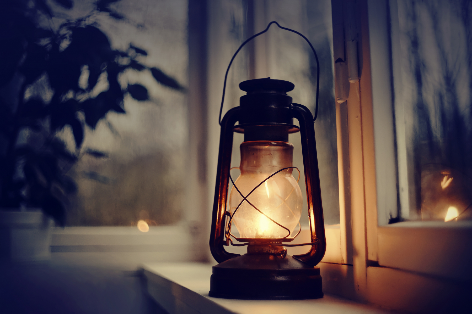Brennende parafinlampe i vinduspost