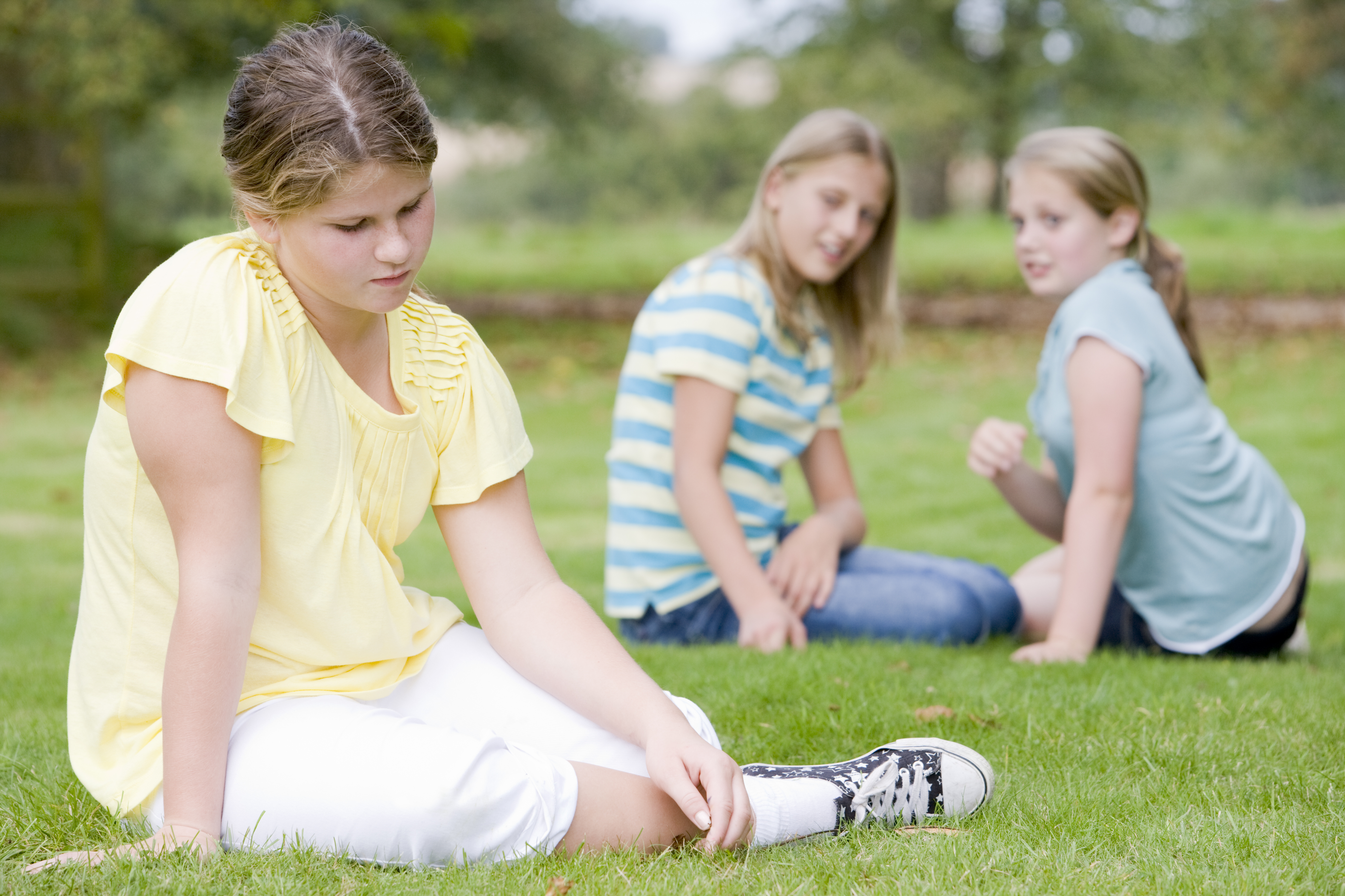 Tre jenter sitter i parken