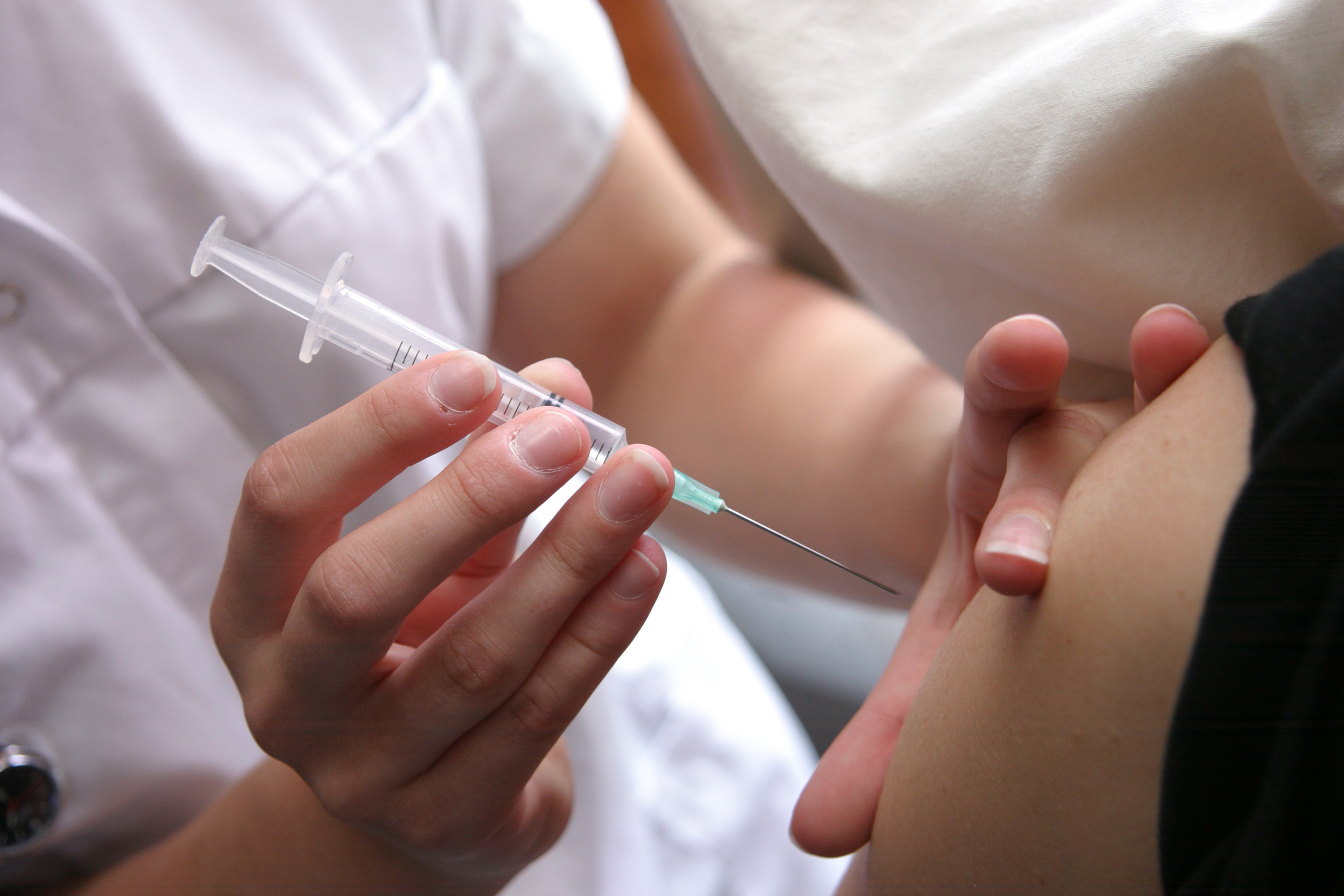 Nurse sets a needle in an upper arm