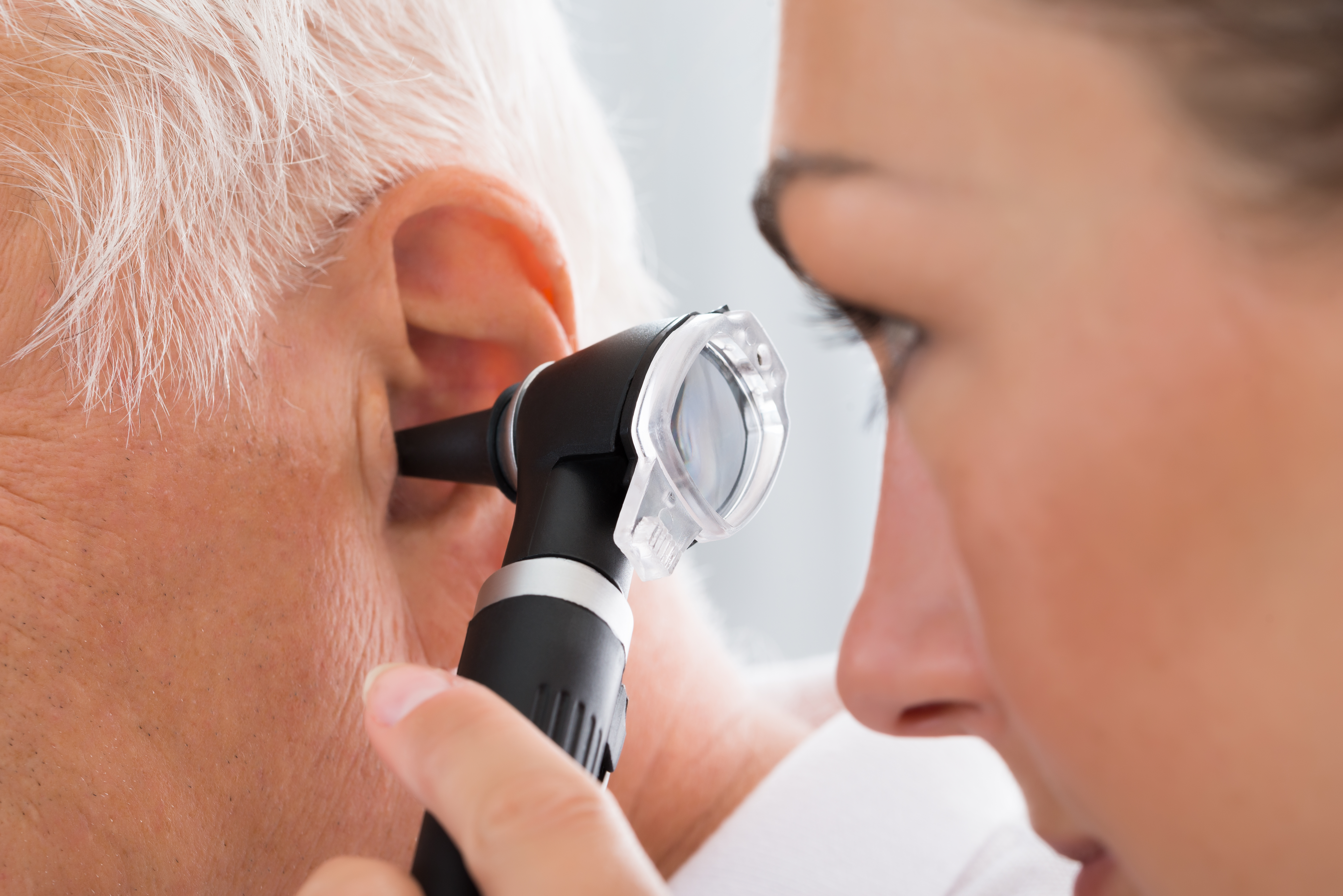Lege undersøker øret til en pasient