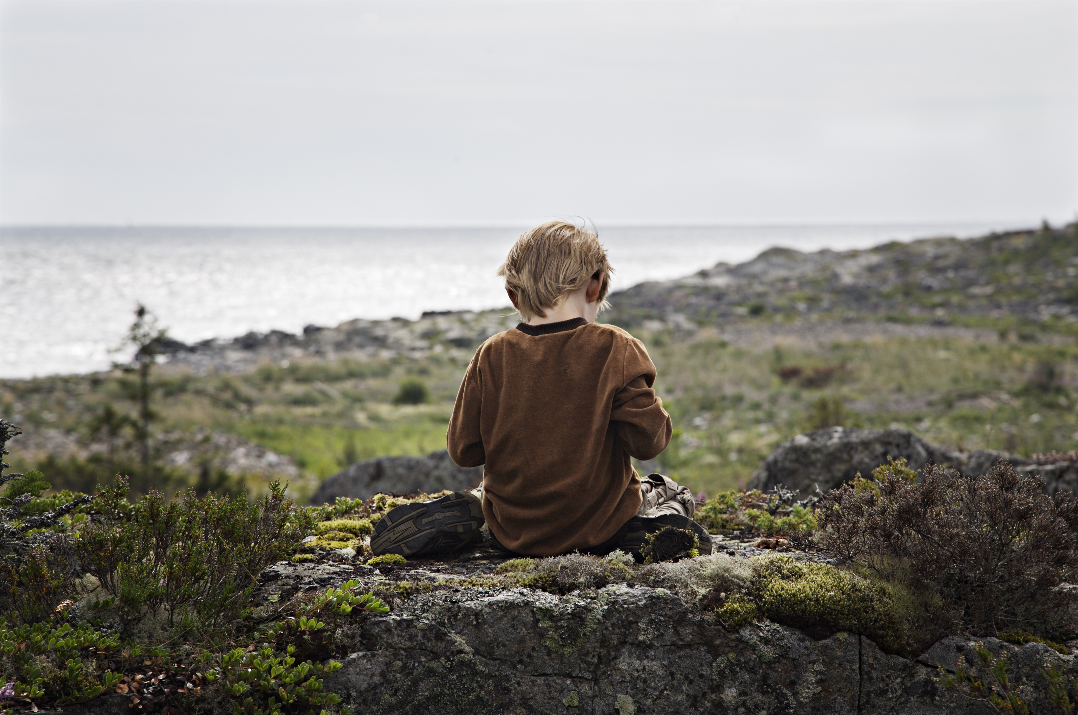 Boy sitting on a rock