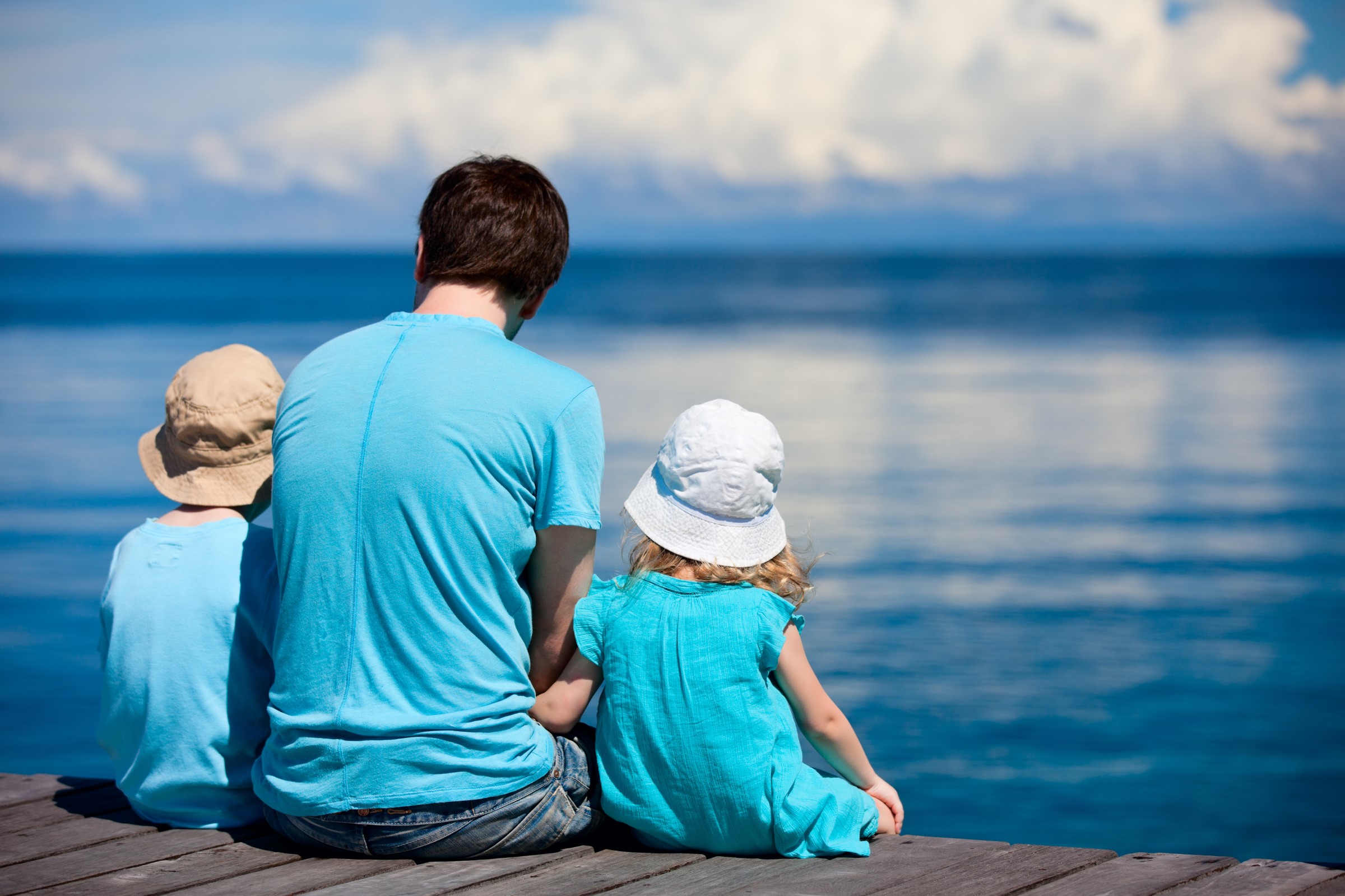 En familie sitter ved vannkanten