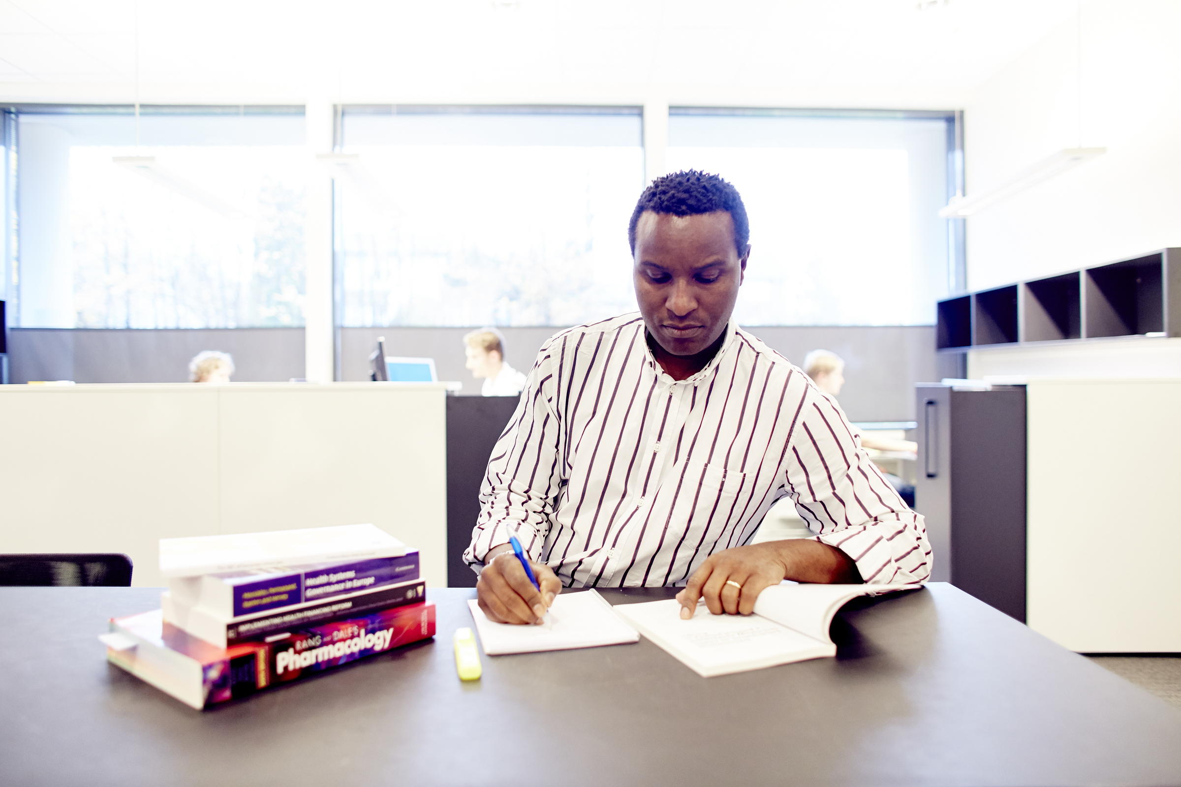 Man sitting at table writing in a book