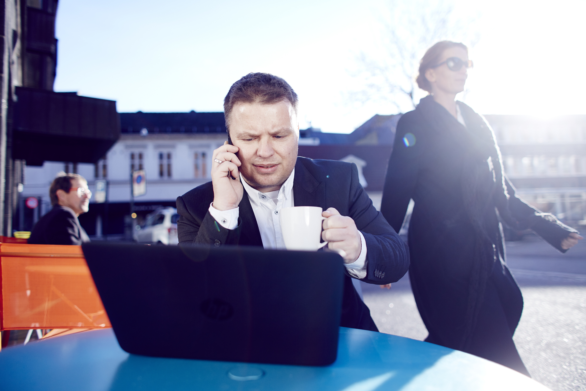 Man with laptop and mobile phone sitting at a table