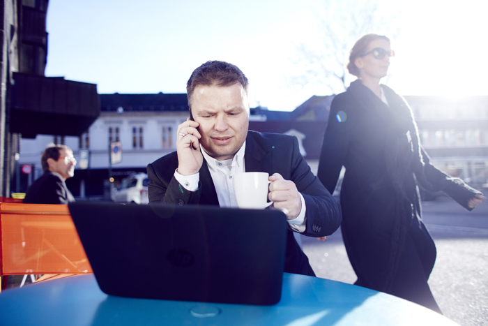 Man with laptop and mobile phone sitting at a table