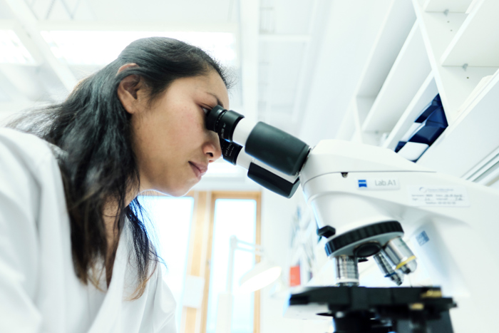  Woman looking into a microscope