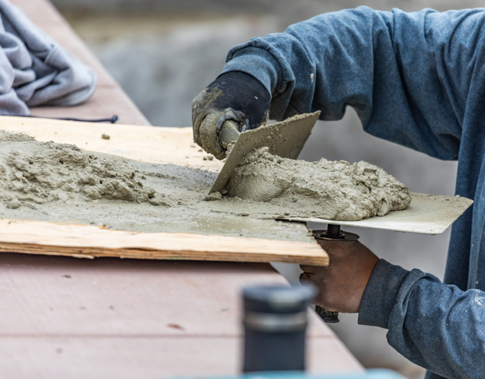 Person som arbeider med uherdet betong med sparkelspade.