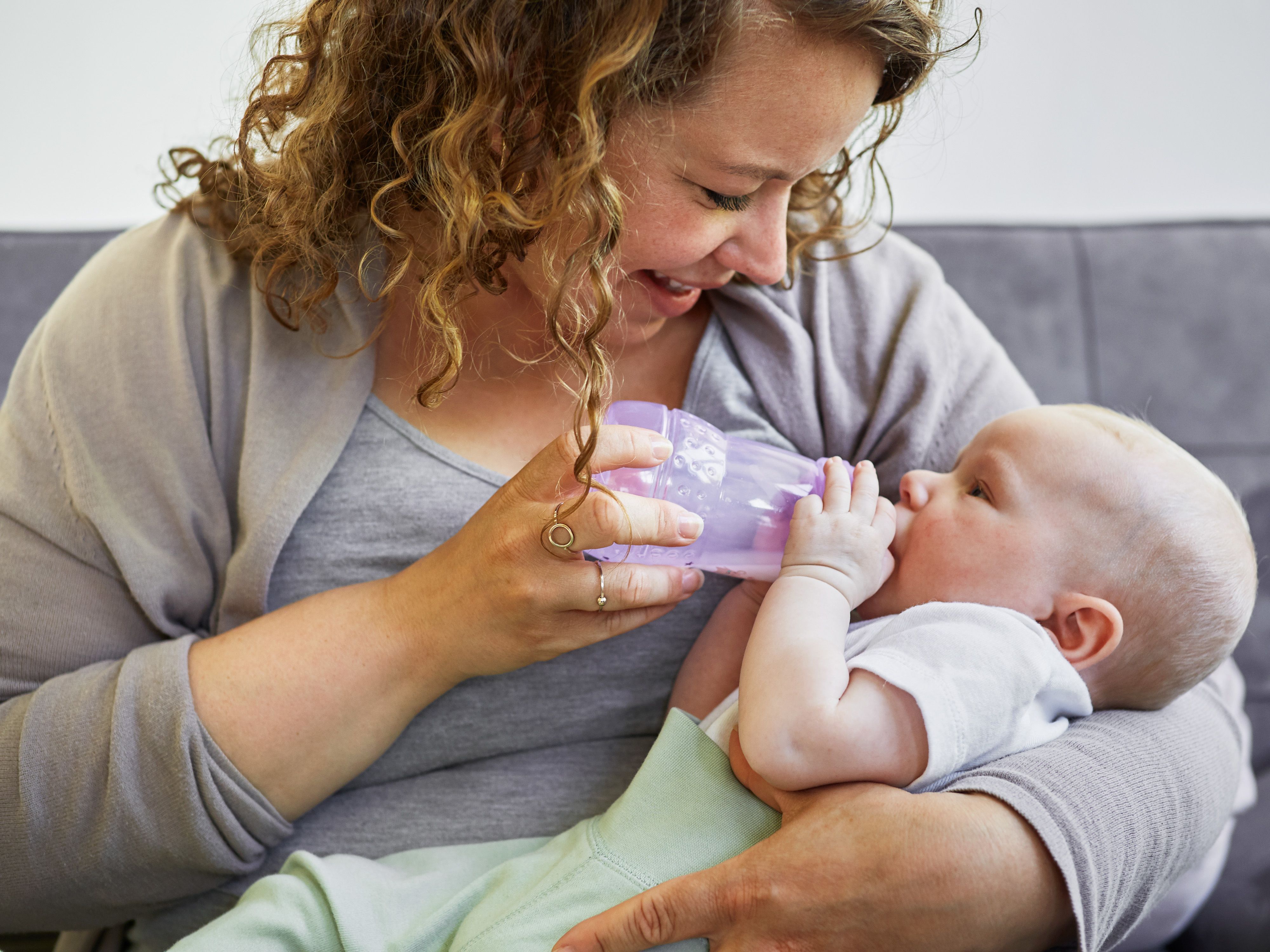 Kvinne gir flaske til baby