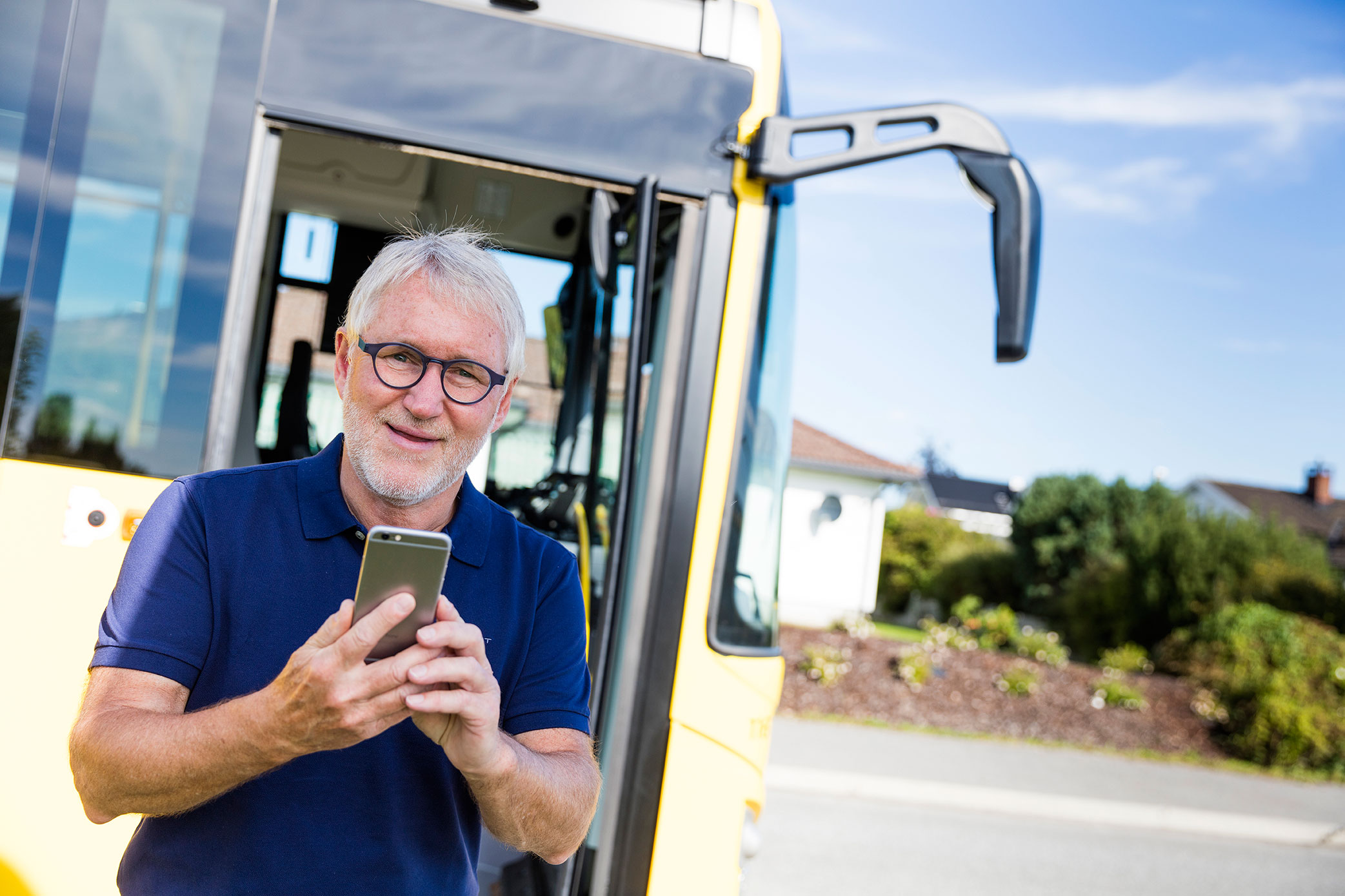 Man med telefon foran buss
