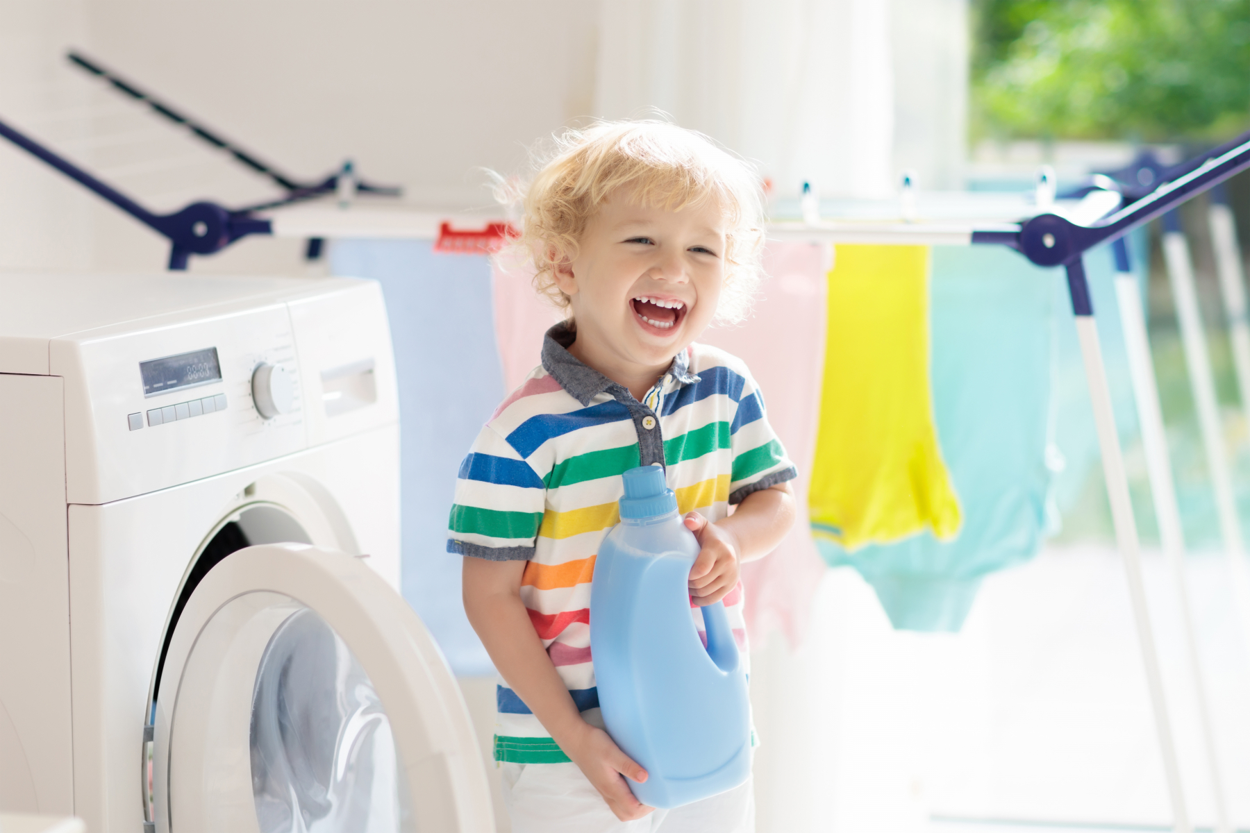 Young child holding a bottle of detergent